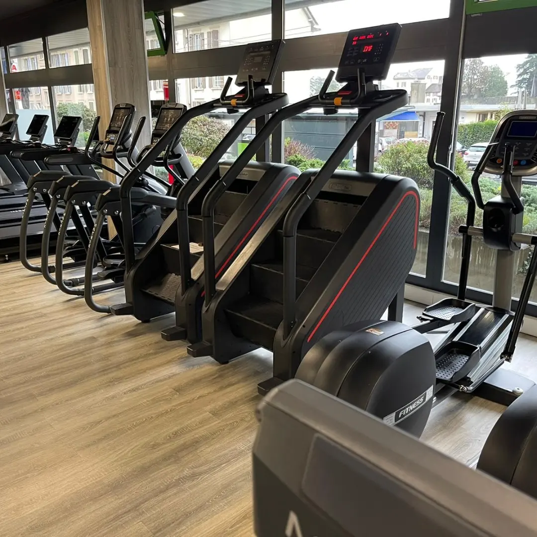 Escaliers d'entraînement et vélos elliptiques devant les baies vitrées